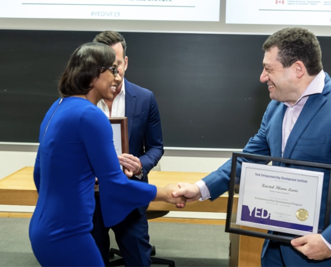 Photo of the YEDI Incubator ceremony, where a participant receives a certificate from an institute representative